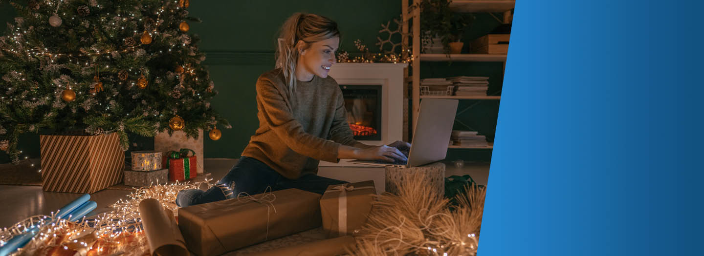 Woman sitting in front of Christmas tree on her laptop